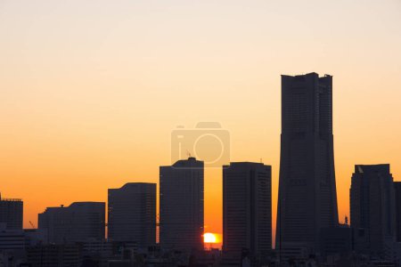 Téléchargez les photos : Magnifique coucher de soleil sur la ville. silhouettes de gratte-ciel sur fond de ciel couchant - en image libre de droit
