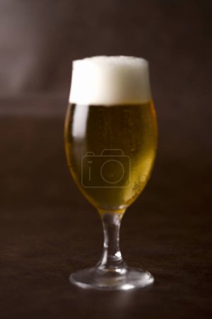 Téléchargez les photos : Tasse de bière avec mousse sur fond sombre - en image libre de droit