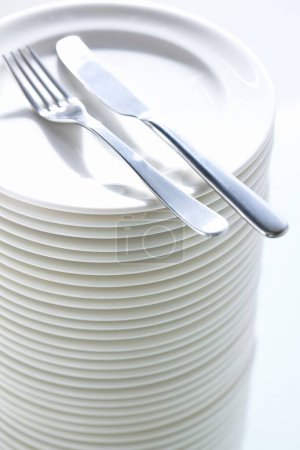 Foto de Platos blancos limpios y cubiertos en la mesa - Imagen libre de derechos