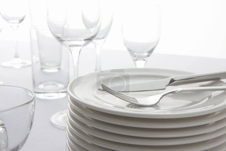 Téléchargez les photos : Assiettes blanches, couverts et verres blancs sur fond blanc. - en image libre de droit