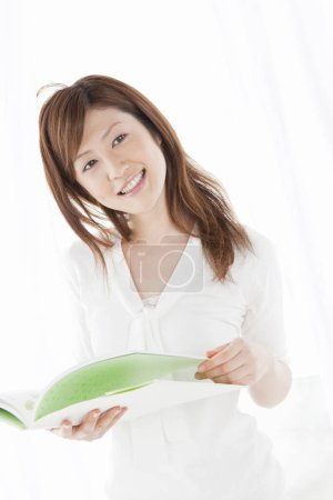 Photo for Young  asian woman reading a book - Royalty Free Image