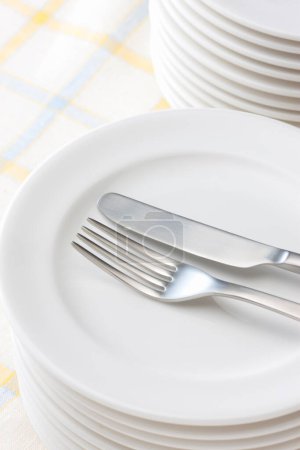 Foto de Tenedor y cuchillo en la pila de platos blancos - Imagen libre de derechos
