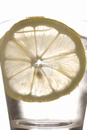 Téléchargez les photos : Tranche de citron en verre avec de l'eau et de la glace - en image libre de droit
