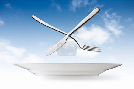 Téléchargez les photos : Assiette vide, fourchette et couteau sur fond de ciel - en image libre de droit