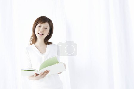 Photo for Young woman reading book - Royalty Free Image
