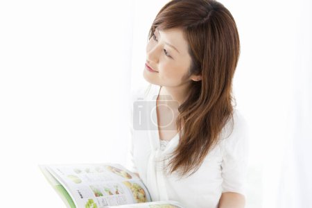 Photo for Young asian woman reading book - Royalty Free Image
