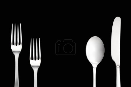 Téléchargez les photos : Cuillère argentée et fourchette sur fond noir - en image libre de droit