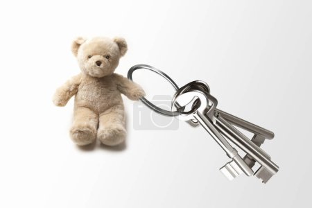 Photo for Teddy bear holding keys isolated on white background - Royalty Free Image