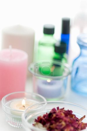 Foto de Juego de frascos naturales con aceites esenciales y velas sobre mesa blanca. Set spa - Imagen libre de derechos