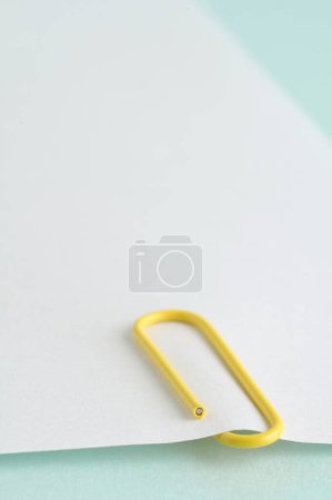 Téléchargez les photos : Trombone jaune et feuille de papier vierge sur fond couleur, gros plan - en image libre de droit