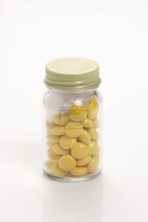 Téléchargez les photos : Pot avec des pilules jaunes isolé sur fond blanc - en image libre de droit