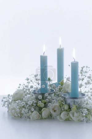 Téléchargez les photos : Vue rapprochée de bougies allumées et de belles fleurs blanches sur fond clair - en image libre de droit