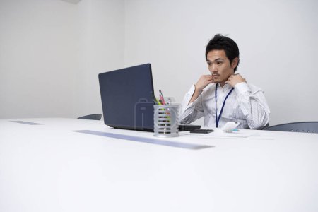 Foto de Joven asiático hombre de negocios trabajando con portátil en la oficina. - Imagen libre de derechos