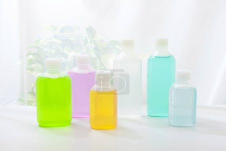 Téléchargez les photos : Vue rapprochée de bouteilles en plastique colorées de liquide sur fond clair - en image libre de droit
