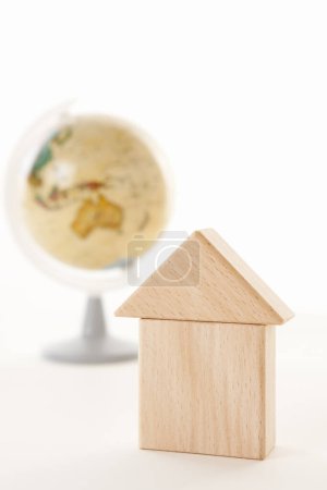 Téléchargez les photos : Miniature maison modèle avec globe sur le fond blanc - en image libre de droit