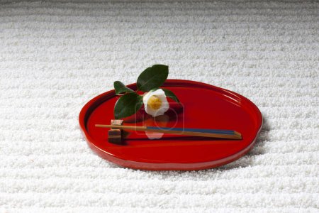 Foto de Abstracto zen patrón de ondas de grava y placa con palillos y flor - Imagen libre de derechos