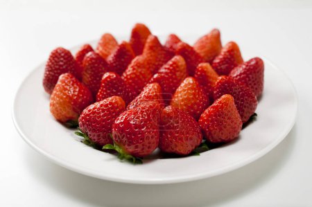 Foto de Vista de cerca de fresas rojas maduras en plato blanco - Imagen libre de derechos