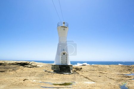 beautiful white lighthouse on shore in Japan