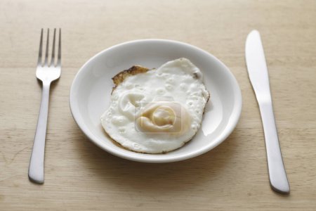Photo for Egg on a white plate on wooden table - Royalty Free Image