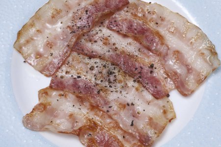 Téléchargez les photos : Bacon frit sur une assiette blanche - en image libre de droit