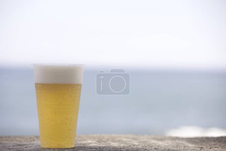Foto de Cerveza en un vaso en la playa - Imagen libre de derechos