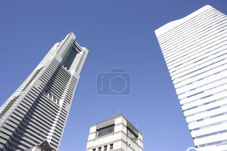 Photo for Low angle view of modern buildings in urban city against blue sky - Royalty Free Image