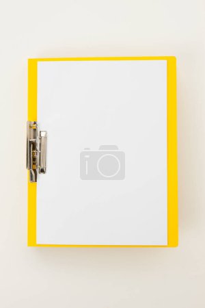 Téléchargez les photos : Presse-papiers blanc jaune sur fond blanc. - en image libre de droit