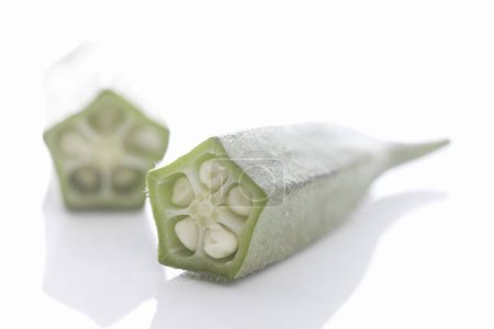 Téléchargez les photos : Légumes okra frais également connu sous le nom de doigts de dame sur fond blanc - en image libre de droit