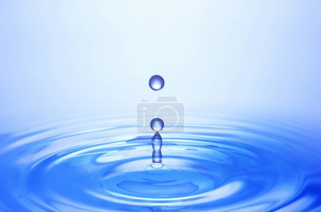 Téléchargez les photos : Vue rapprochée des gouttes d'eau bleue tombant dans l'eau - en image libre de droit
