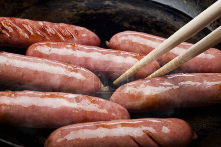 Téléchargez les photos : Vue rapprochée de savoureuses saucisses cuisinées dans une poêle - en image libre de droit
