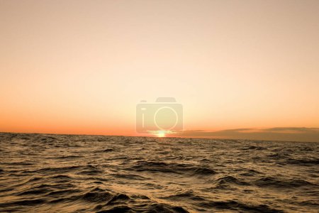 Téléchargez les photos : Magnifique coucher de soleil au-dessus des vagues de mer dans la soirée - en image libre de droit
