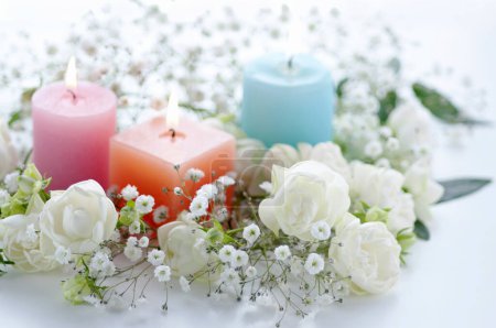 Photo for Close-up view of burning candles and beautiful white flowers on light background - Royalty Free Image