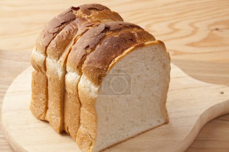 Photo for Fresh sliced bread on a wooden board, closeup - Royalty Free Image