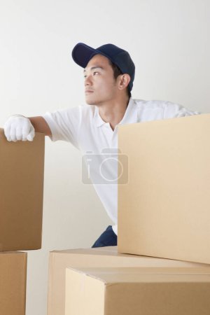 Photo for Young male courier with boxes in warehouse - Royalty Free Image