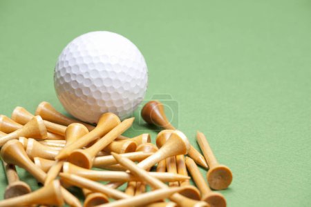 Téléchargez les photos : Vue rapprochée de la balle de golf et des tee-shirts sur fond vert - en image libre de droit