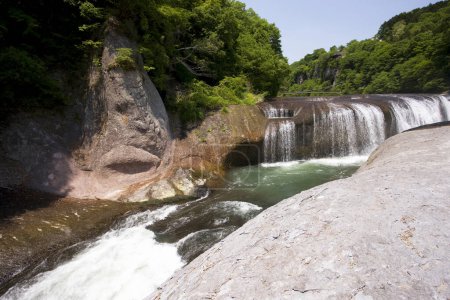 Téléchargez les photos : Une cascade avec une grande roche au milieu - en image libre de droit