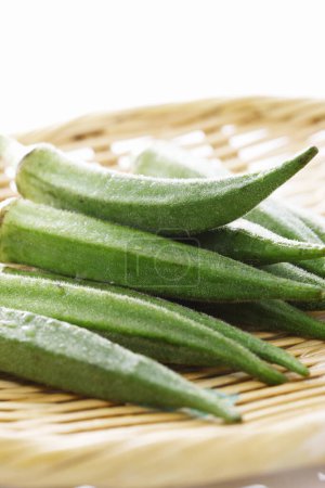 Téléchargez les photos : Légumes okra frais également connu sous le nom doigts de dame sur assiette en bois - en image libre de droit