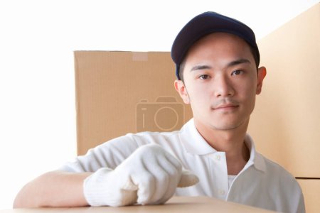 Téléchargez les photos : Asiatique homme en uniforme avec des boîtes - en image libre de droit