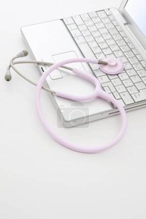 Photo for Medical stethoscope, laptop and notebook on a white background - Royalty Free Image
