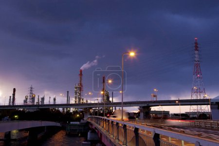 Foto de Fábrica industrial con tuberías contra el cielo del atardecer - Imagen libre de derechos