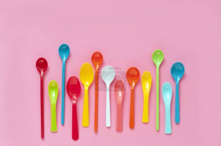 Photo for Colorful plastic cutlery set on pink background. top view - Royalty Free Image