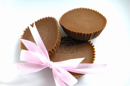 Photo for Chocolate candies with pink bow on background, close up - Royalty Free Image
