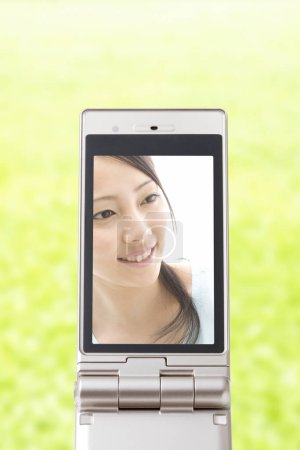 Téléchargez les photos : Technologie et concept de communication arrière-plan de l'écran de téléphone mobile avec belle image de femme asiatique - en image libre de droit