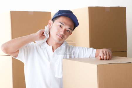 Photo for Asian  delivery man in tired with boxes on background - Royalty Free Image