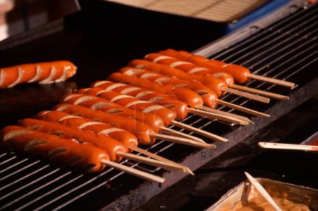Téléchargez les photos : Un gril avec hot-dogs en arrière-plan, gros plan - en image libre de droit