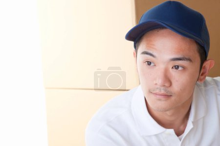 Photo for Young asian  delivery man wearing cap - Royalty Free Image