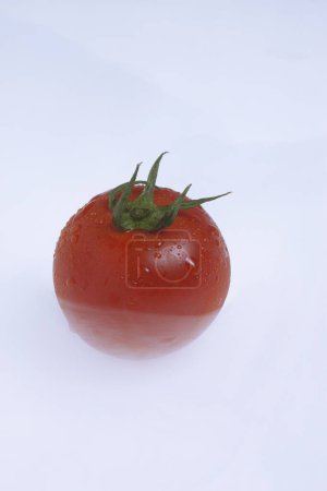 Téléchargez les photos : Tomate rouge fraîche avec des gouttes d'eau sur fond blanc - en image libre de droit