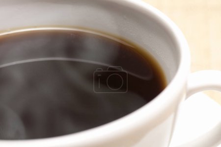 Photo for Cup of black coffee with steam on the wooden background. - Royalty Free Image