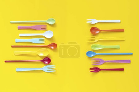 Photo for Colorful plastic cutlery set on yellow background. top view - Royalty Free Image