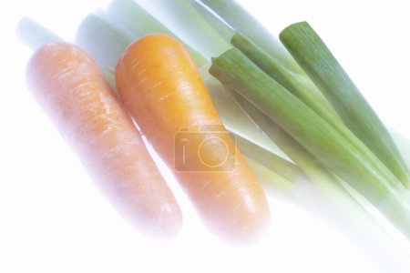 Foto de Zanahorias frescas con cebollas verdes aisladas sobre fondo blanco. - Imagen libre de derechos